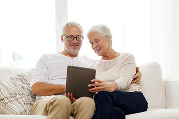 Image showing happy senior couple with tablet pc at home