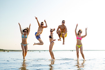 Image showing smiling friends in sunglasses on summer beach
