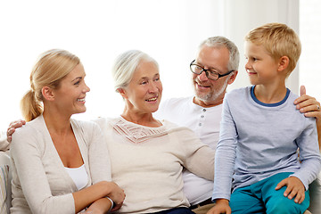 Image showing happy family sitting on couch at home