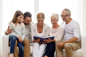 Image showing happy family with book or photo album at home