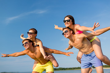 Image showing smiling friends having fun on summer beach