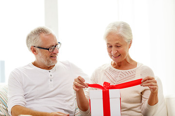 Image showing happy senior couple with gift box at home