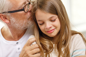 Image showing grandfather with crying granddaughter at home