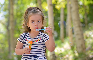 Image showing little girl blowing soap bubbles