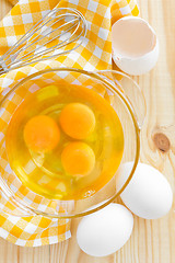 Image showing Raw eggs and whisk