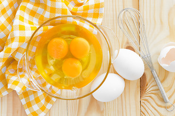 Image showing Raw eggs and whisk