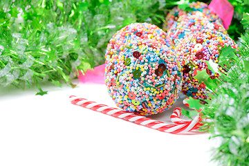 Image showing Green tinsel with Christmas balls and candy canes