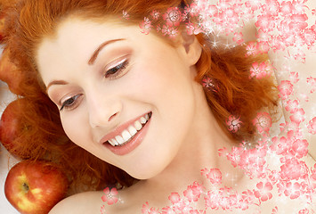 Image showing lovely redhead with red apples and flowers