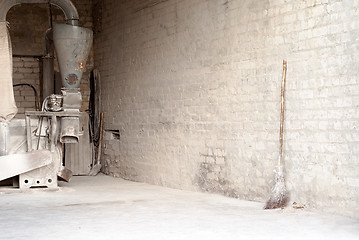 Image showing electric corn mill and wooden broom at the wall