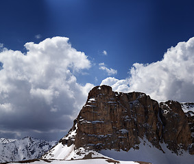 Image showing Panorama of snowy rocks and sky with sunbeam in nice spring day