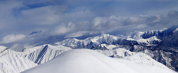 Image showing Off-piste snowy slope and cloudy mountains