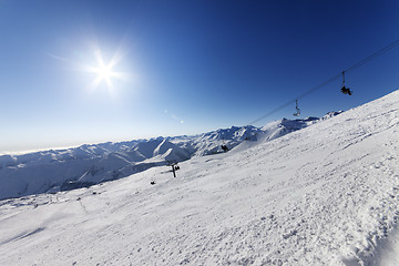 Image showing Off-piste slope and blue sky with sun