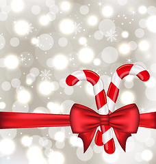 Image showing Christmas glowing background with gift bow and sweet canes