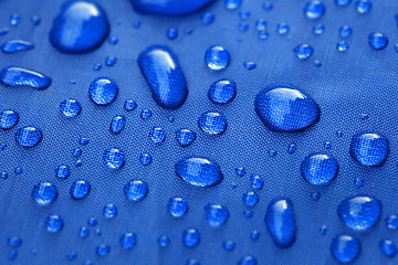 Image showing Closeup of rain drops on a blue umbrella