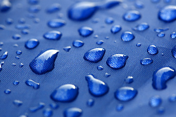 Image showing Closeup of rain drops on a blue umbrella