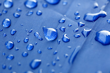 Image showing Closeup of rain drops on a blue umbrella