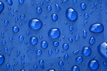 Image showing Closeup of rain drops on a blue umbrella