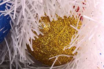 Image showing Golden christmas ball on shining glitter background close-up