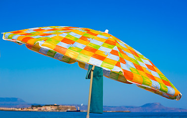 Image showing Sunshades and clothes on a sea beach  