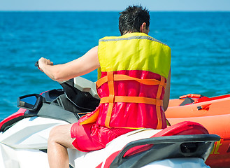 Image showing The young man prepares for a sea trip on the water bike.