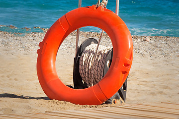 Image showing Lifebuoy at water on the coast of a sea beach.