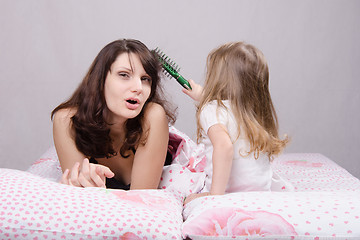 Image showing Mom hurt by combing hair daughter