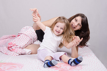 Image showing Mom and daughter having fun in the three-year bed