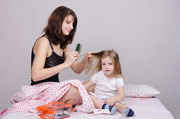 Image showing Mom combing her daughter in the morning