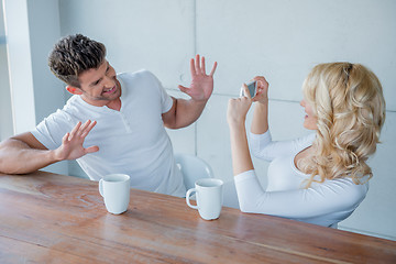 Image showing Blond woman photographing her husband