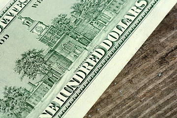 Image showing Close-up of a 100 dollars banknotes on wooden background