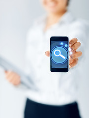 Image showing close up of businesswoman showing smartphone