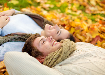 Image showing close up of smiling couple lying in autumn park