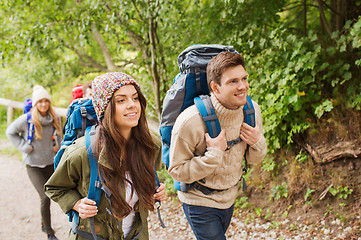 Image showing group of smiling friends with backpacks hiking