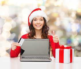 Image showing smiling woman with credit card and laptop