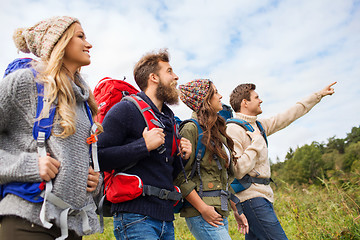 Image showing group of smiling friends with backpacks hiking