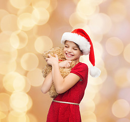 Image showing smiling girl in santa helper hat with teddy bear