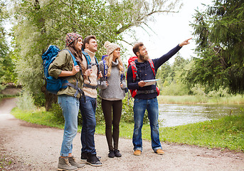 Image showing group of smiling friends with backpacks hiking