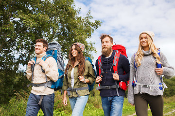 Image showing group of smiling friends with backpacks hiking