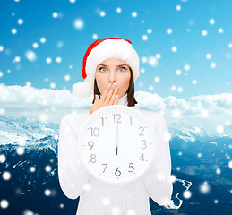 Image showing woman in santa helper hat with clock showing 12