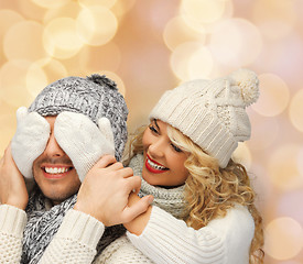 Image showing smiling couple in sweaters and santa helper hats