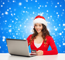 Image showing smiling woman with credit card and laptop