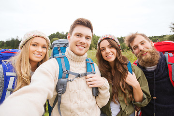 Image showing group of smiling friends with backpacks hiking