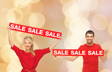 Image showing smiling man and woman with red sale signs