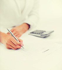 Image showing businesswoman working with calculator in office