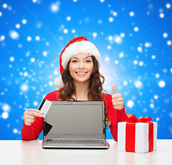 Image showing smiling woman with credit card and laptop