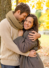 Image showing smiling couple hugging in autumn park