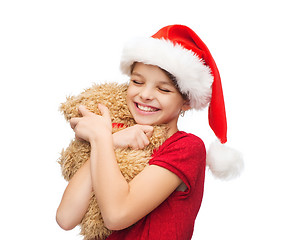 Image showing smiling girl in santa helper hat with teddy bear