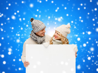 Image showing smiling couple in winter clothes with white board
