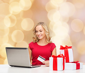 Image showing smiling woman with credit card and laptop