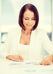 Image showing businesswoman working with graphs in office